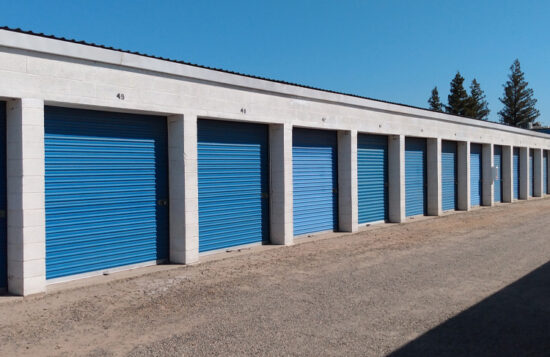 Service representative holding clipboard in front of blue storage containers